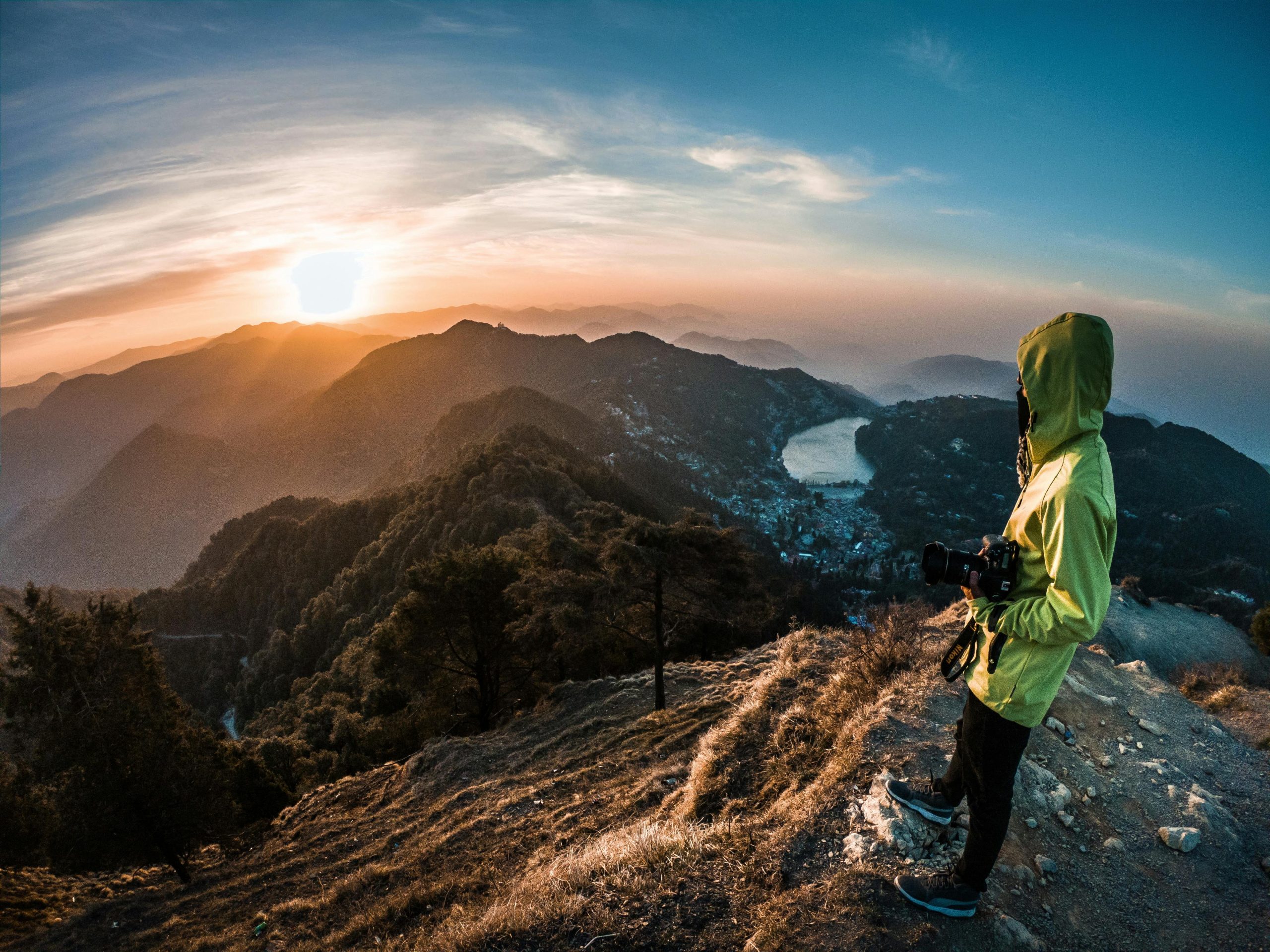 A lone adventurer photographs the breathtaking sunrise over Nainital's mountains.